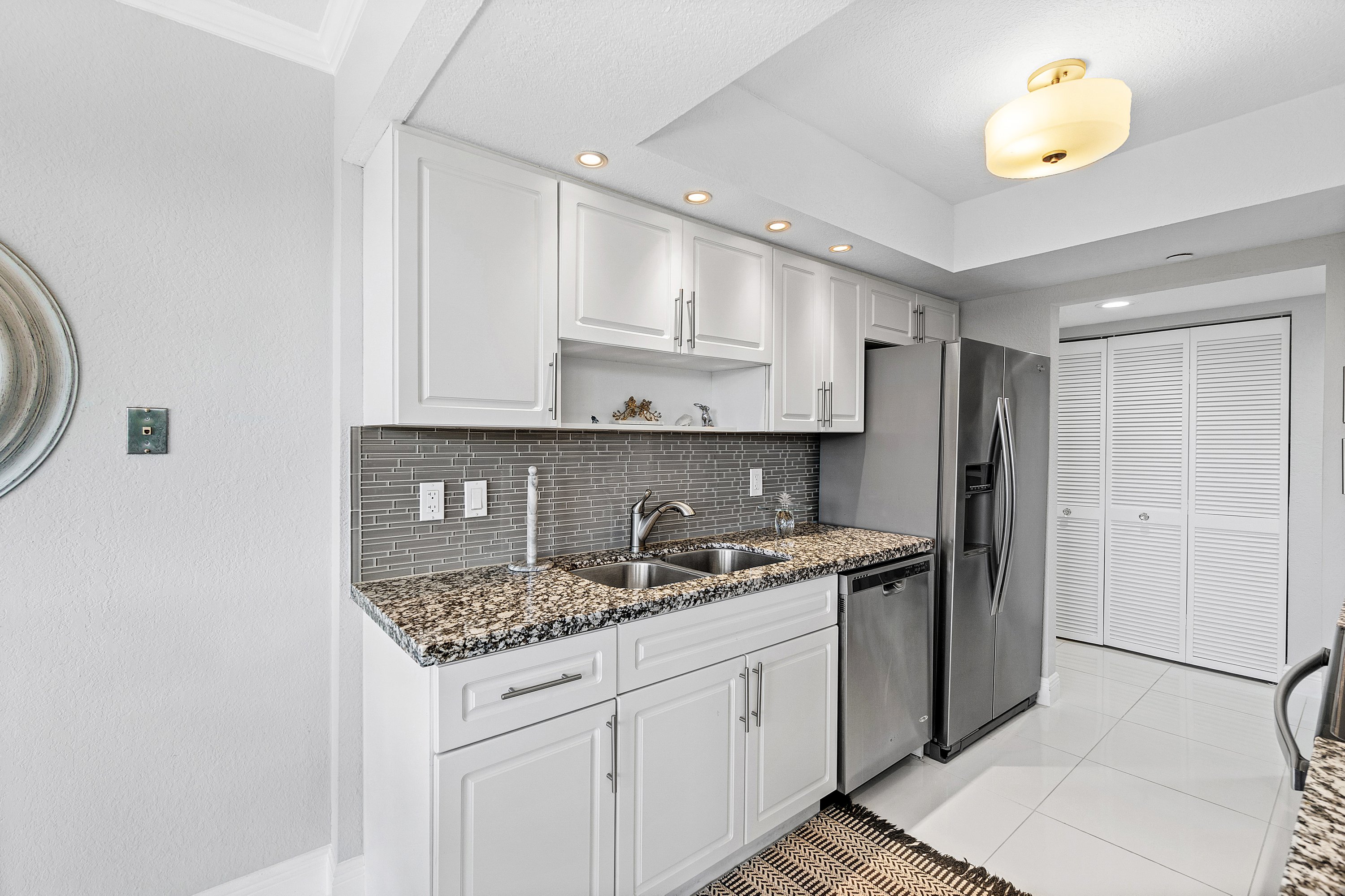 2003 North Ocean Boulevard, Unit 305 Boca Raton, FL 33431 - Photo 31 of 56 a kitchen with stainless steel appliances granite countertop a sink stove and refrigerator