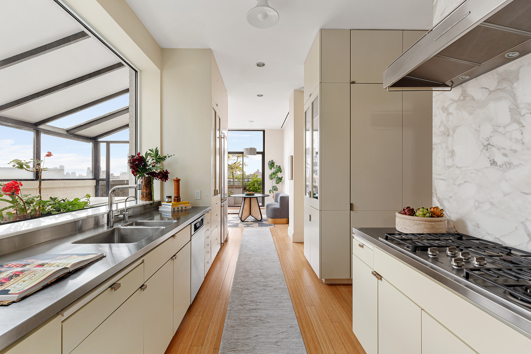 14 East 90th Street, Unit PHW Manhattan, NY 10128 - Photo 11 of 25 a kitchen with stainless steel appliances a stove a sink and a refrigerator