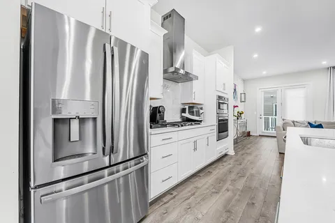a large white kitchen with stainless steel appliances