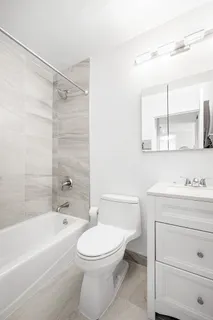 a bathroom with a toilet a sink a mirror and bathtub