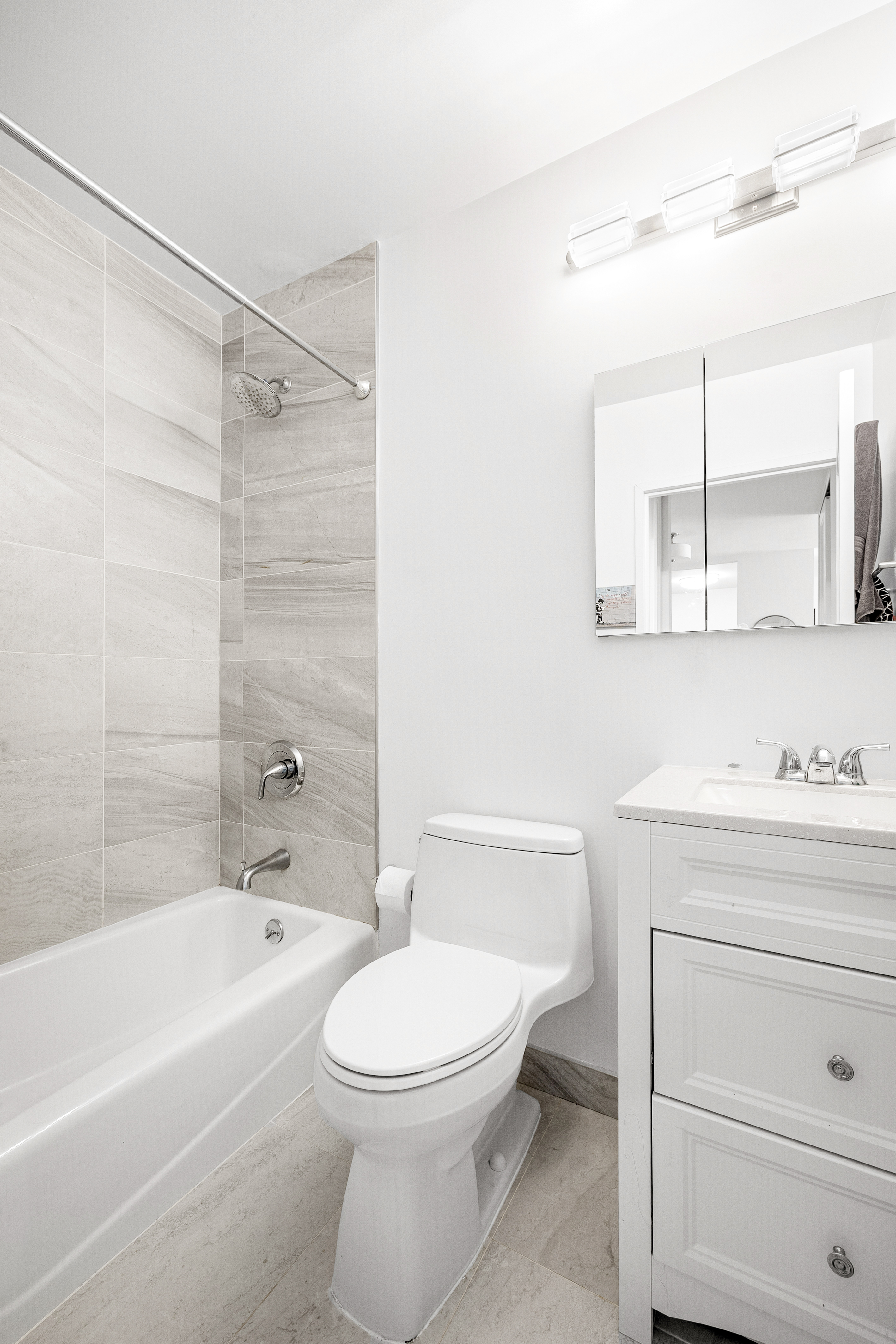 61 West 62nd Street, Unit 17L Manhattan, NY 10023 - Photo 7 of 10 a bathroom with a toilet a sink a mirror and bathtub
