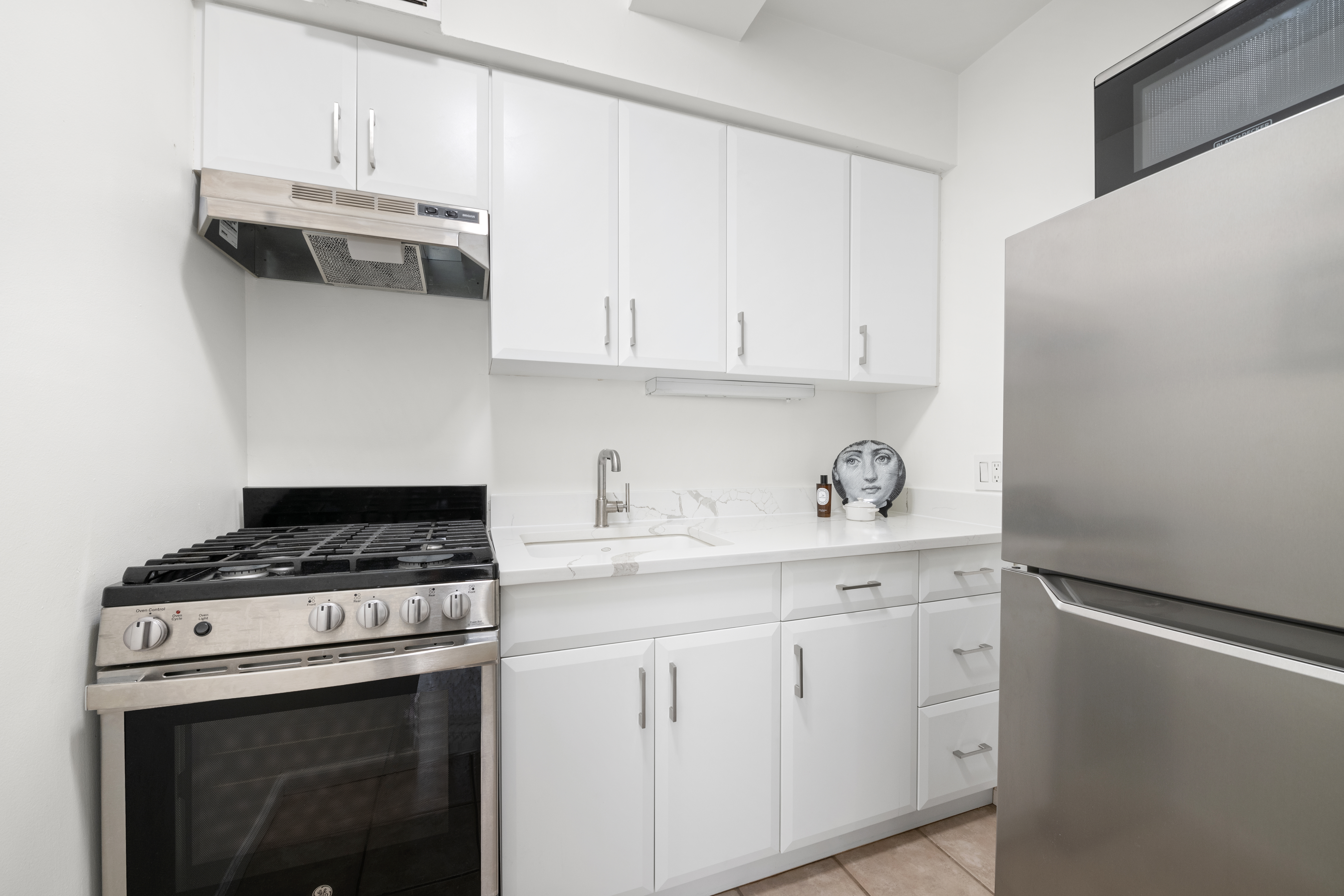 111 Hicks Street, Unit 6E Brooklyn, NY 11201 - Photo 4 of 11 a kitchen with granite countertop white cabinets and white stove