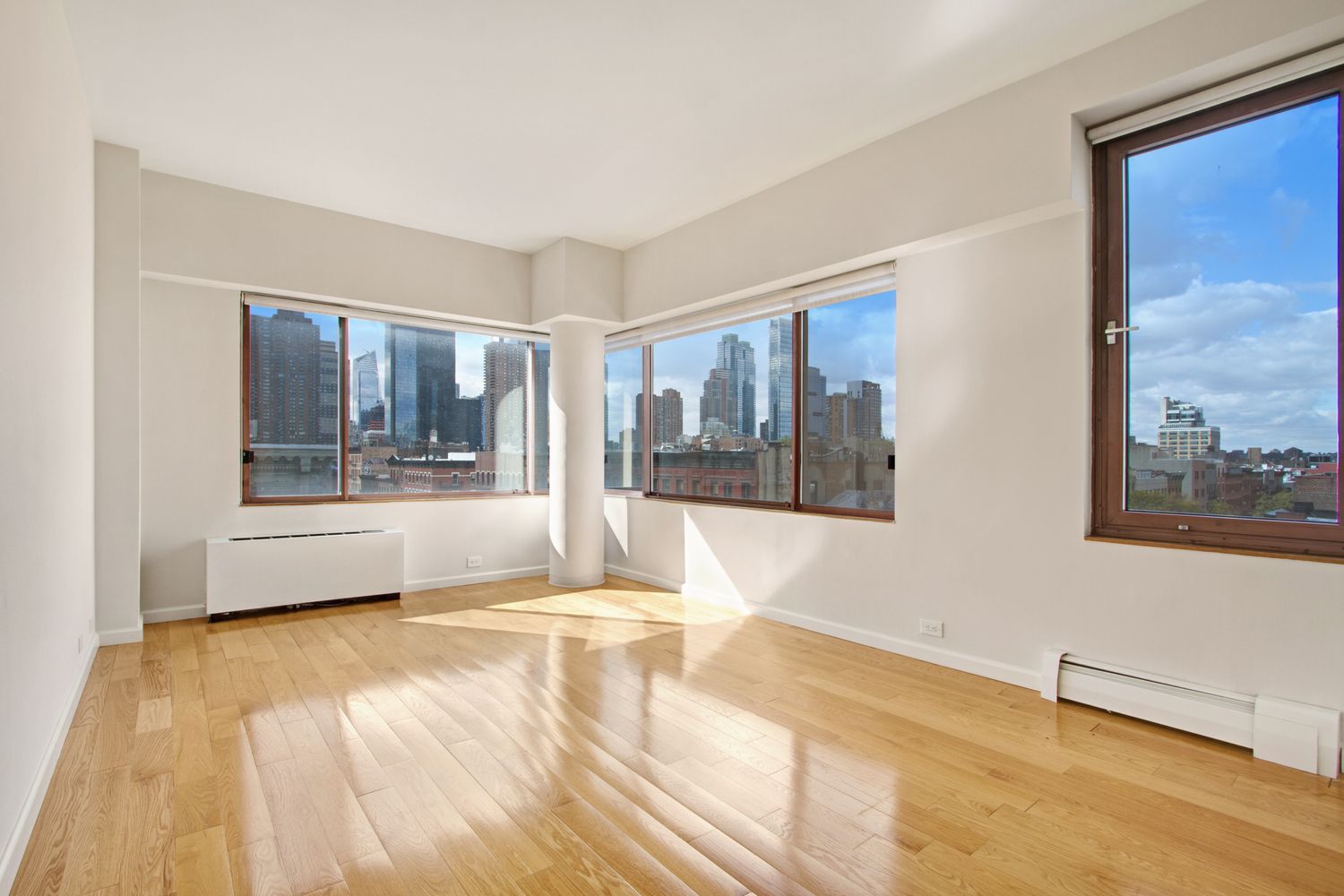 393 West 49th Street, Unit 6G Manhattan, NY 10019 - Photo 7 of 11 a view of an empty room with wooden floor and a window
