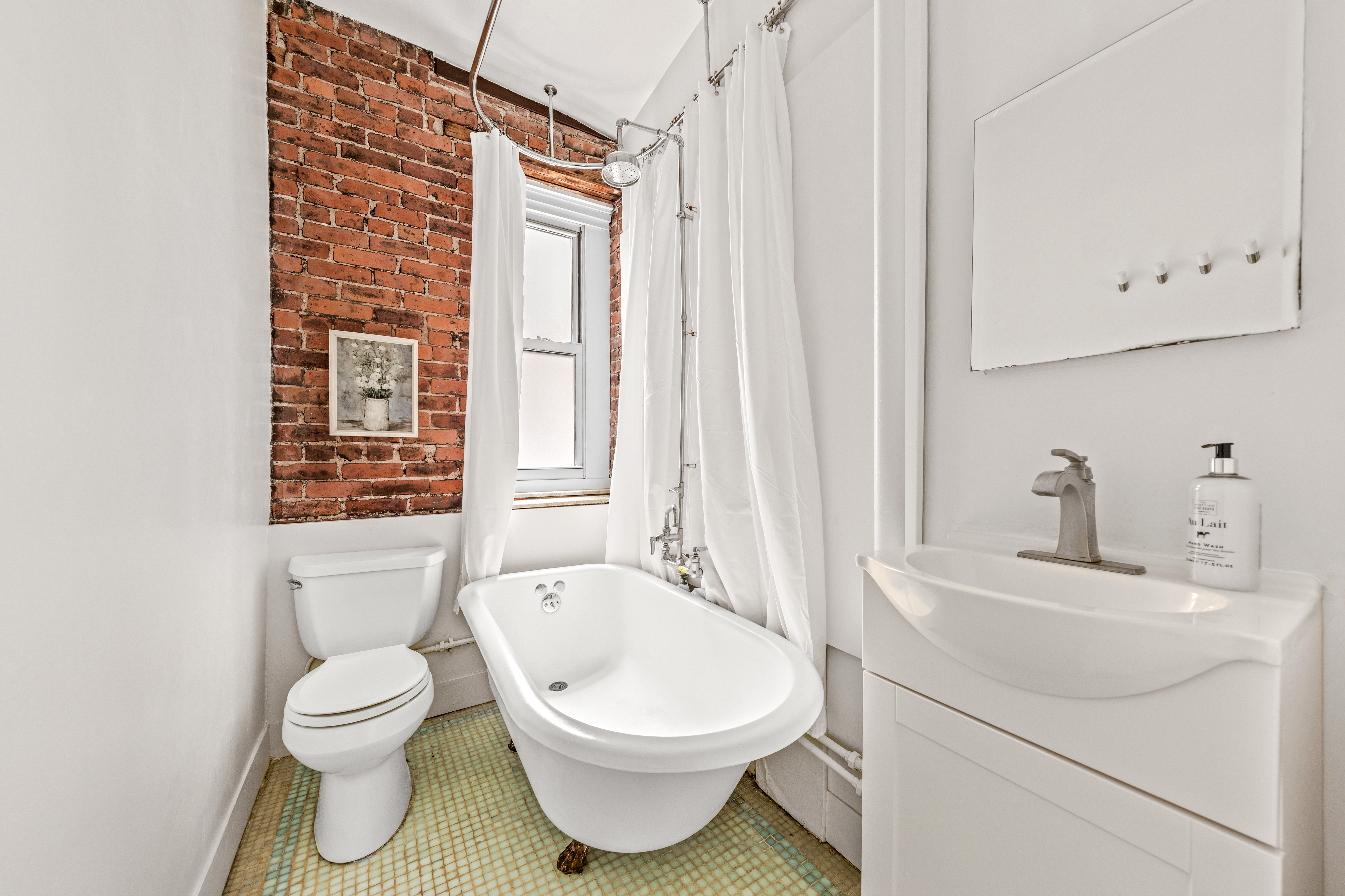 317 West 93rd Street, Unit 1C Manhattan, NY 10025 - Photo 6 of 9 a bathroom with a toilet a sink and a bathtub