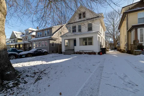 a view of a house with a yard covered with snow in the background