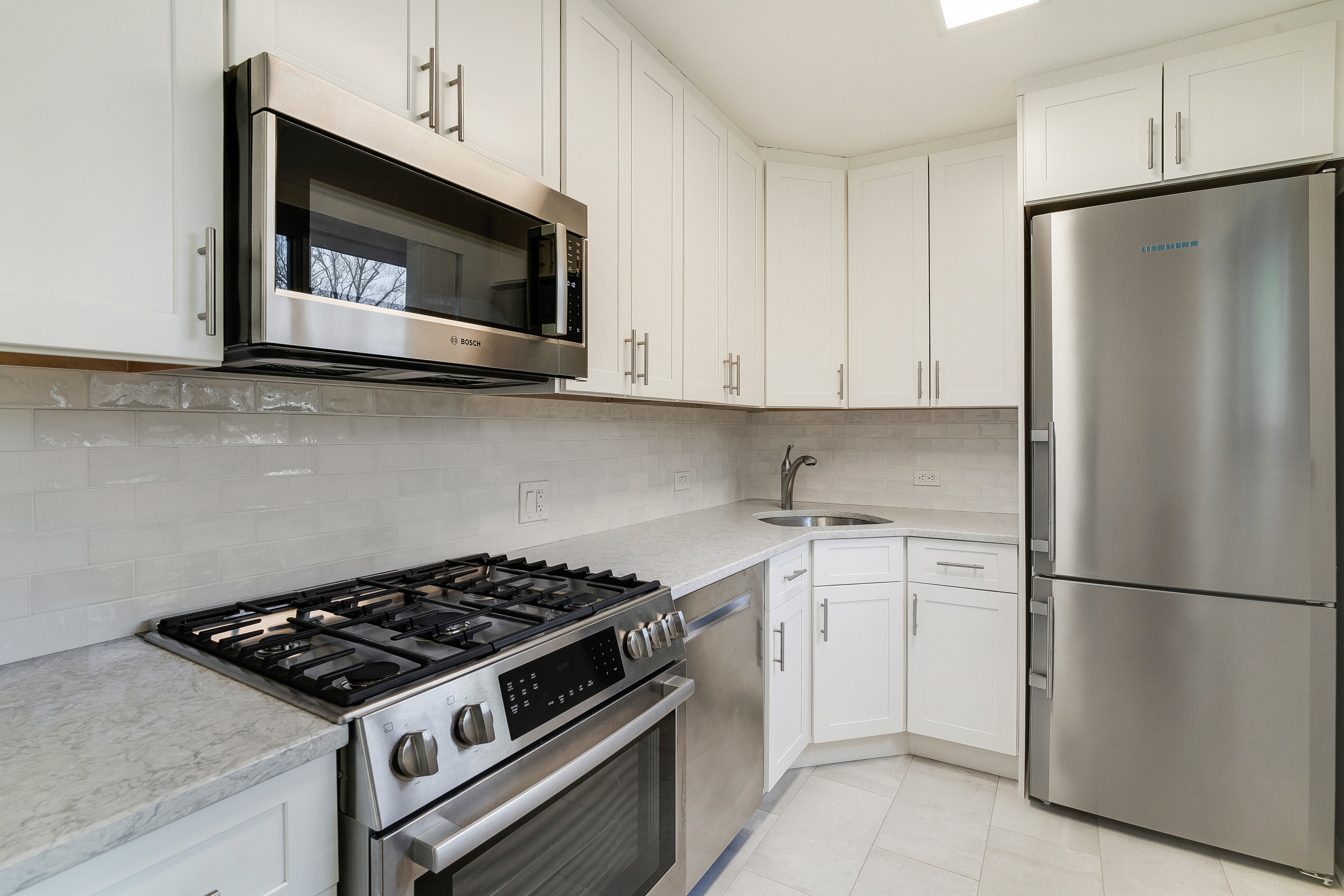 4455 Douglas Avenue, Unit 8A Bronx, NY 10471 - Photo 8 of 22 a kitchen with stainless steel appliances white cabinets and a stove top oven
