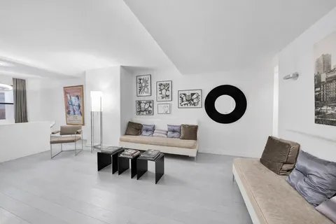 a living room with furniture a mirror and a lamp