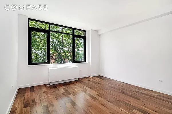125 North 5th Street, Unit 2E Brooklyn, NY 11249 - Photo 3 of 11 an empty room with wooden floor and windows