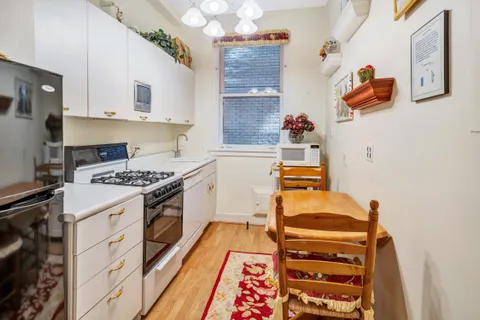 a kitchen with a stove and white cabinets