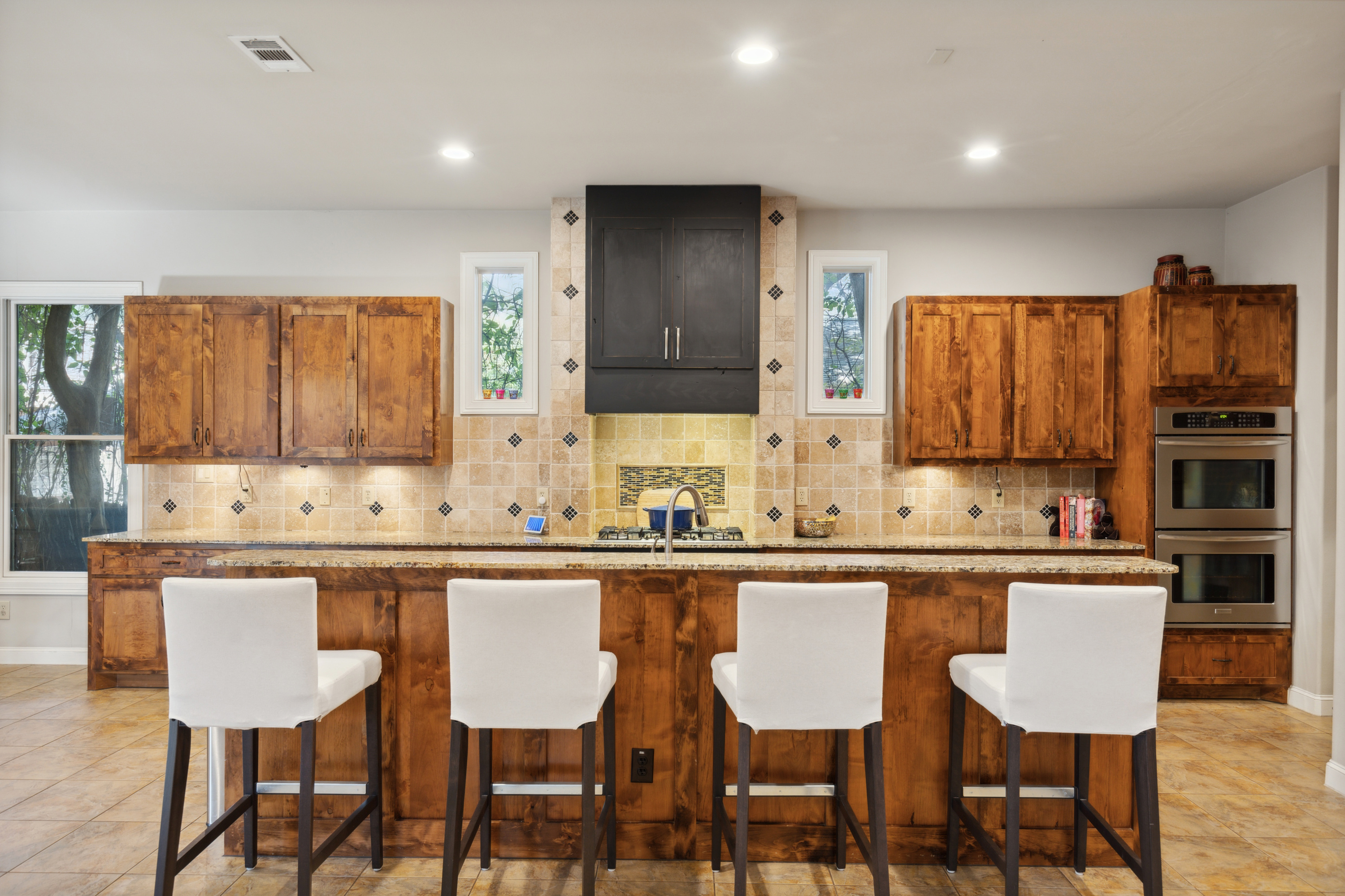 8411 Midway Road Dallas, TX 75209 - Photo 11 of 29 a kitchen with stainless steel appliances a dining table chairs and wooden cabinets