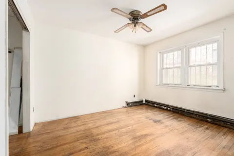 an empty room with a window and a fan
