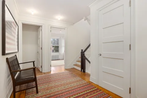a view of a hallway with wooden floor and staircase