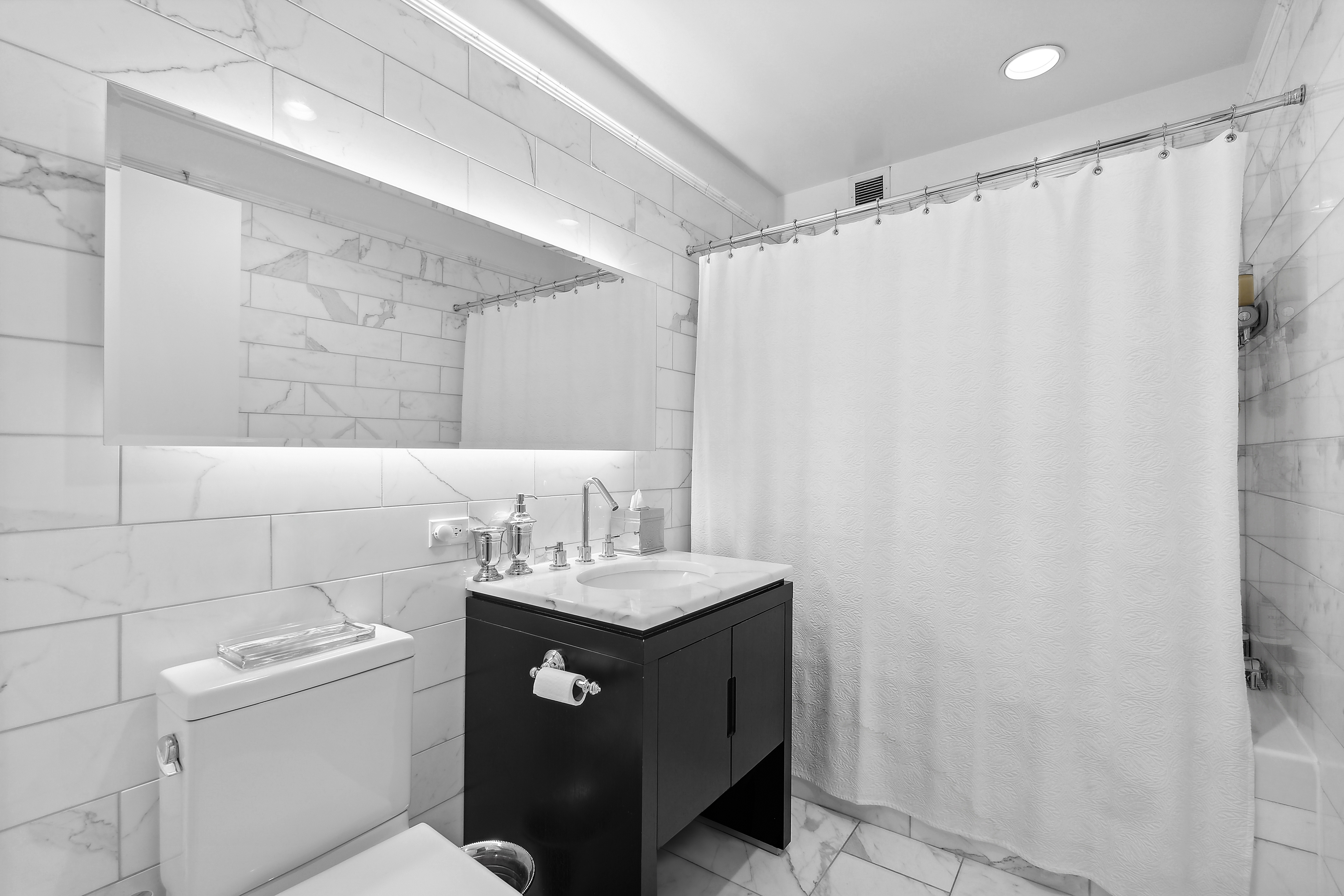 225 5th Avenue, Unit 7K Manhattan, NY 10010 - Photo 9 of 14 a bathroom with a sink a toilet and shower