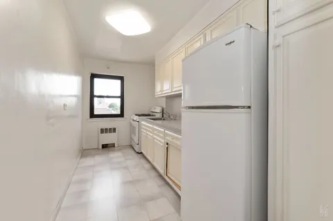 a kitchen with white cabinets and white appliances
