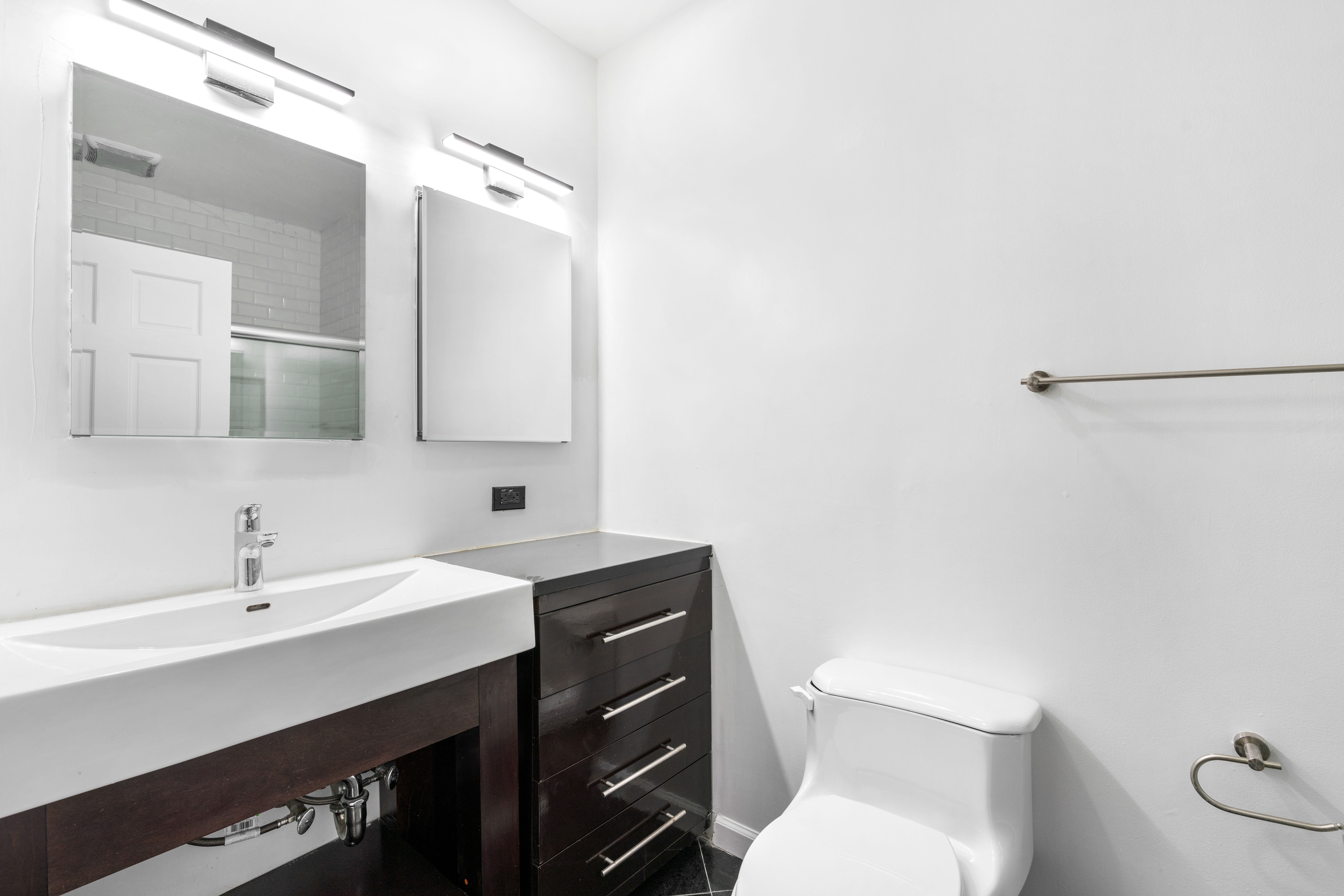 152 East 74th Street, Unit 2 Manhattan, NY 10021 - Photo 14 of 16 a bathroom with a sink a toilet a mirror and vanity