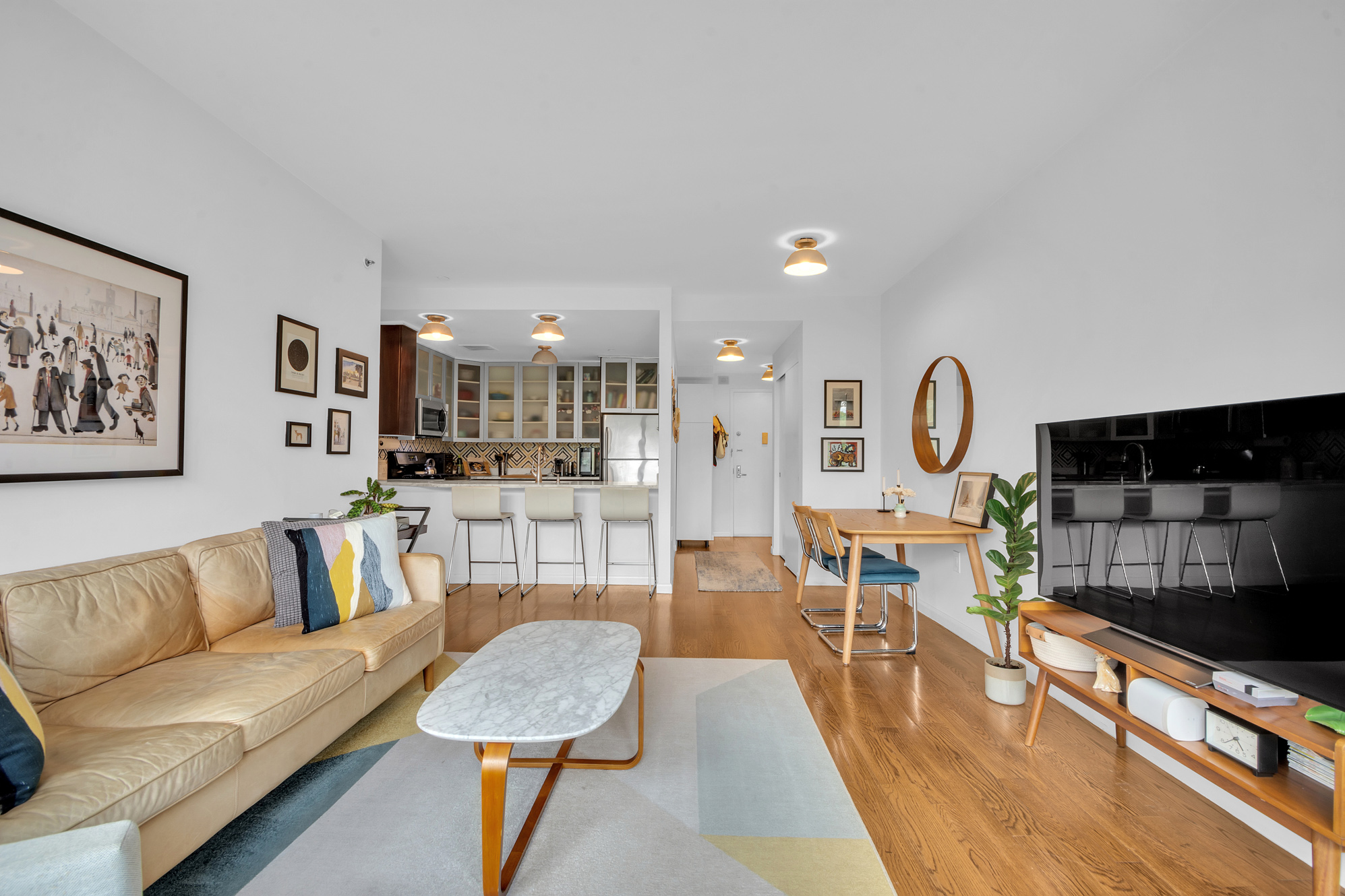2002 5th Avenue, Unit 5B Manhattan, NY 10035 - Photo 3 of 7 a living room with furniture and a view of kitchen