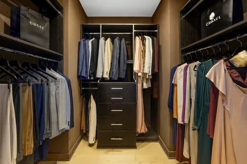a view of walk in closet with clothes and shoes