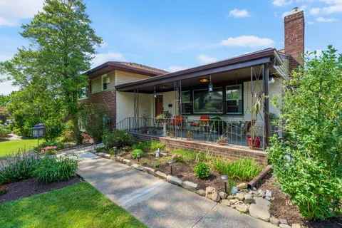 a view of a house with backyard sitting area and swimming pool