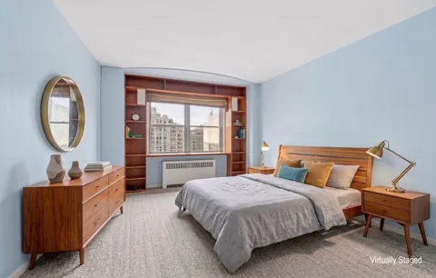 a bedroom with a bed a mirror and a window