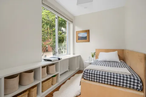 a bedroom with a bed and a large window