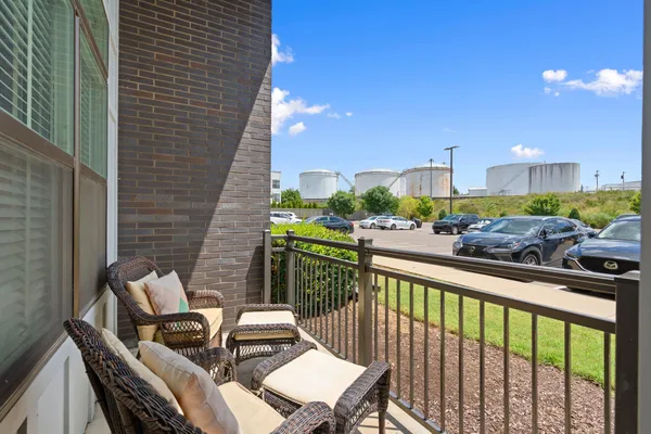 a view of a balcony with a potted plant and outdoor seating
