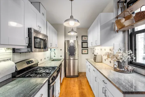 a kitchen with stainless steel appliances granite countertop a stove a sink and a refrigerator