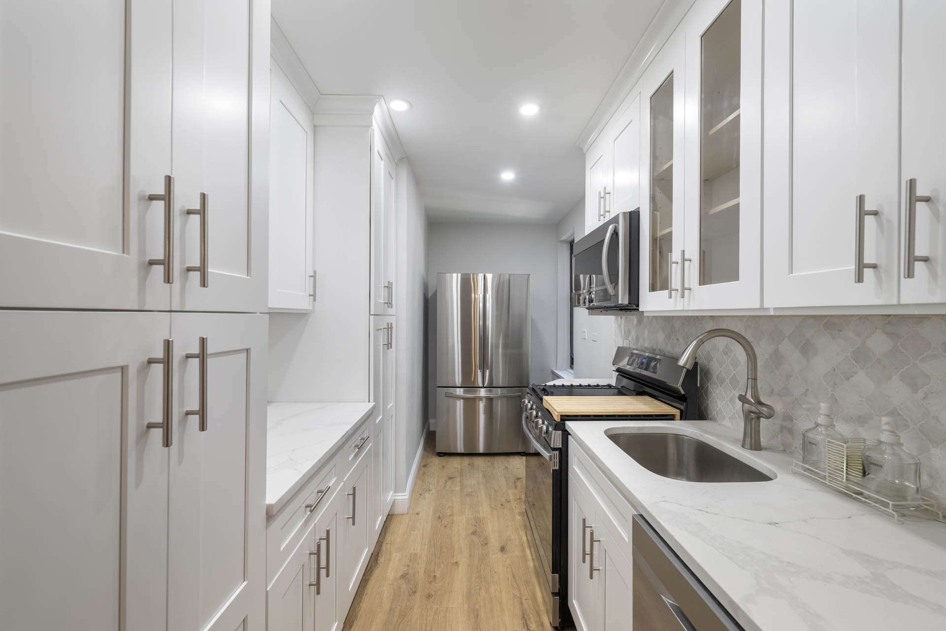 3215 Netherland Avenue, Unit 5C Bronx, NY 10463 - Photo 7 of 14 a kitchen with granite countertop a sink stove and refrigerator