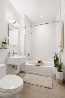 a bathroom with a sink a mirror a toilet and a bathtub