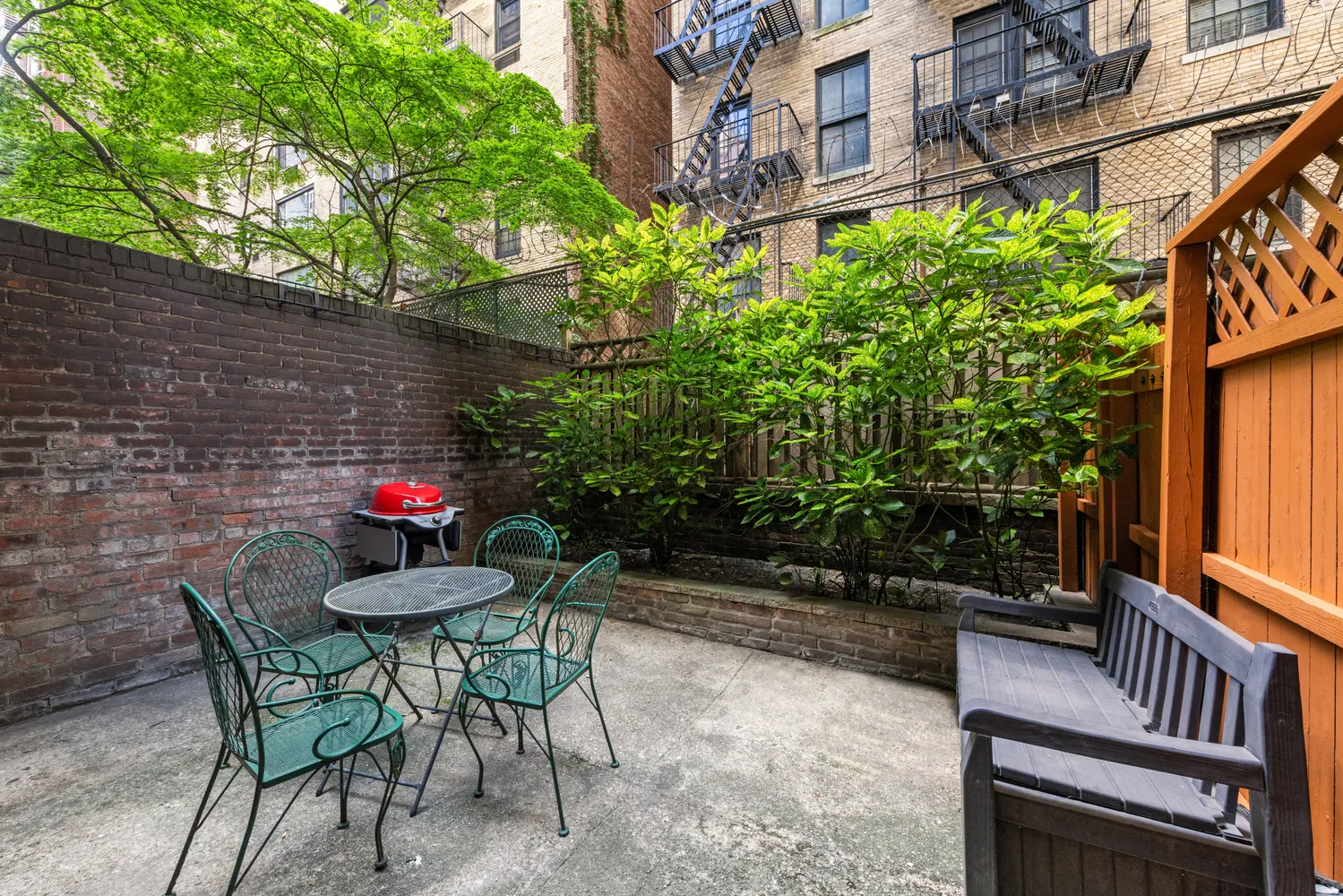 a backyard of a house with table and chairs and wooden fence