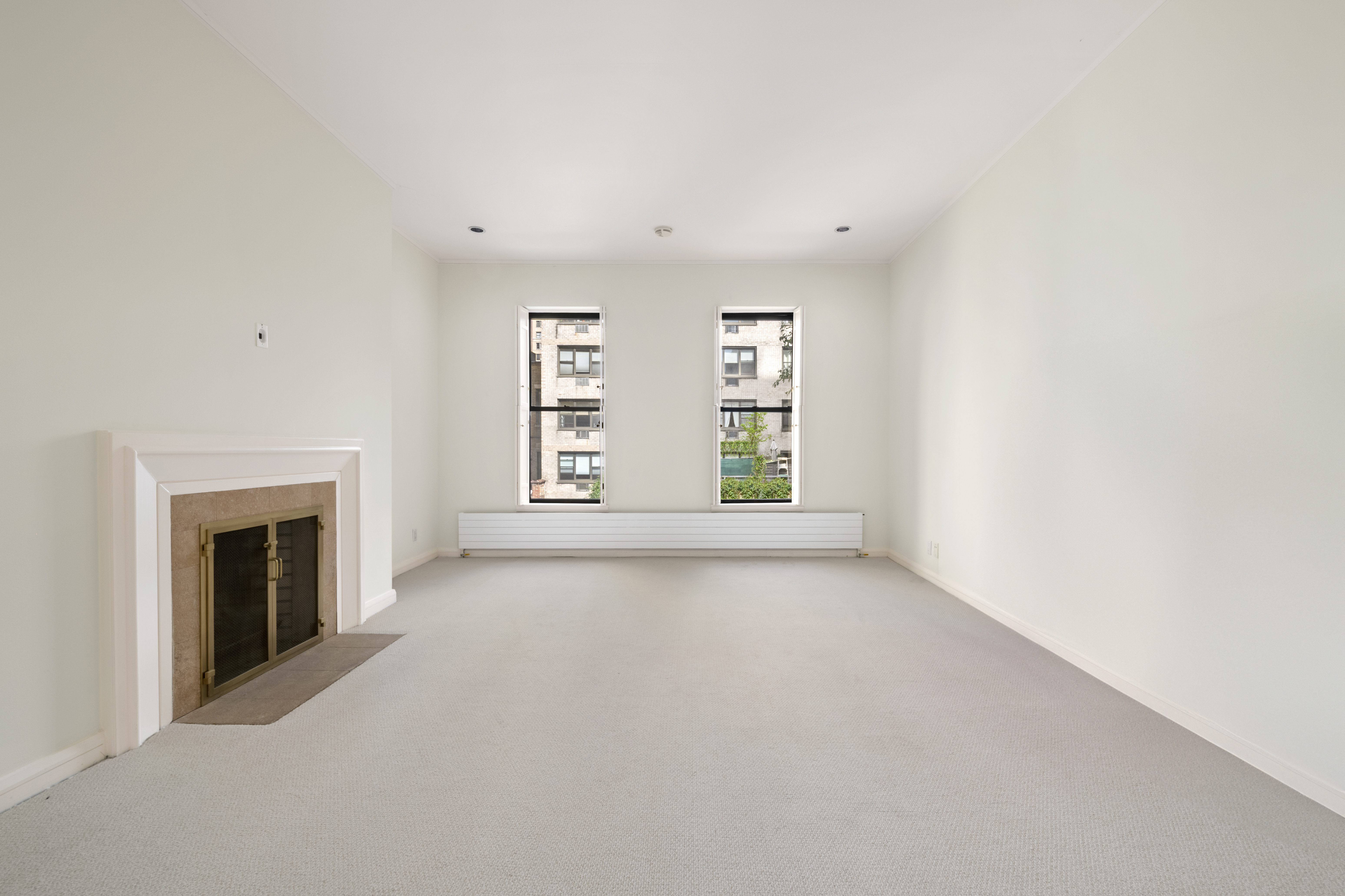 313 West 102nd Street Manhattan, NY 10025 - Photo 33 of 36 an empty room with windows and fireplace