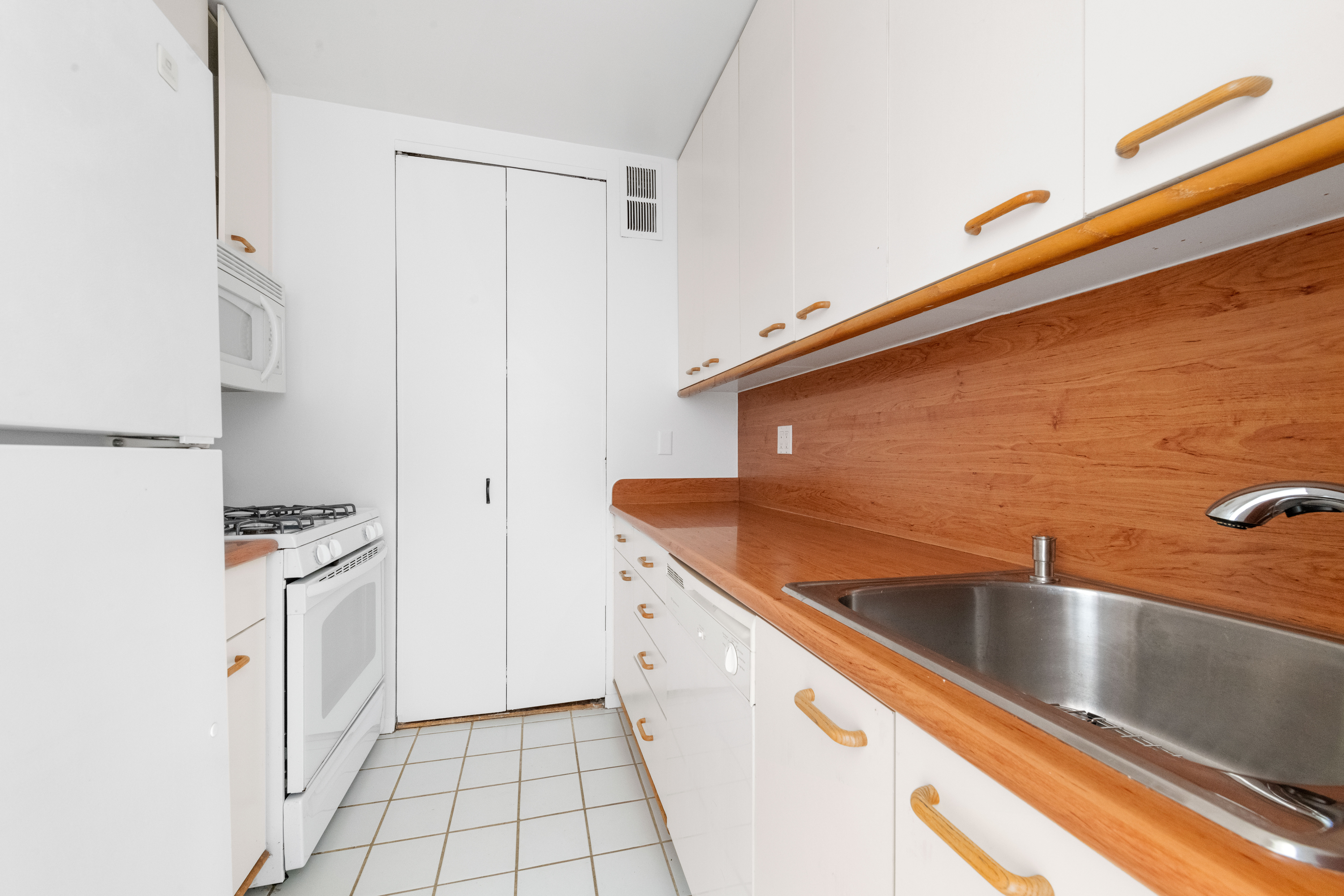 350 West 50th Street, Unit 12B Manhattan, NY 10019 - Photo 7 of 16 a kitchen with a sink stove and cabinets