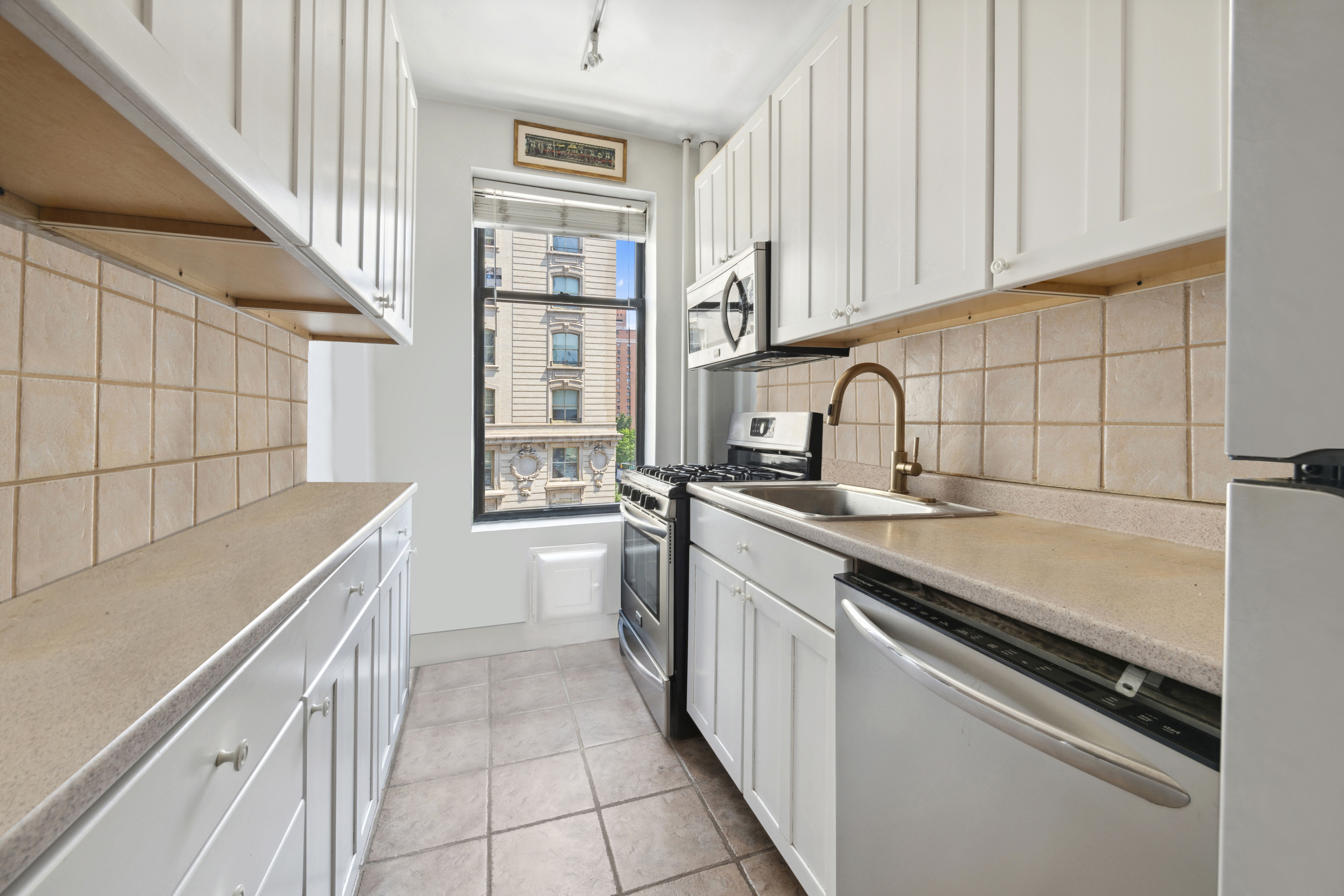 200 West 86th Street, Unit 7C Manhattan, NY 10024 - Photo 5 of 14 a kitchen with stainless steel appliances a sink dishwasher stove and white cabinets with wooden floor