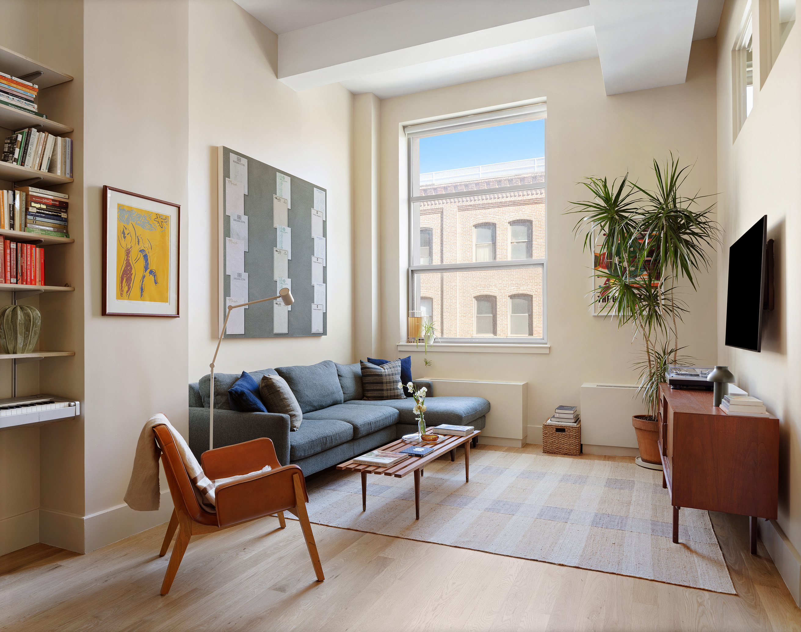 55 Berry Street, Unit 3D Brooklyn, NY 11249 - Photo 3 of 12 a living room with furniture a bookshelf and a window