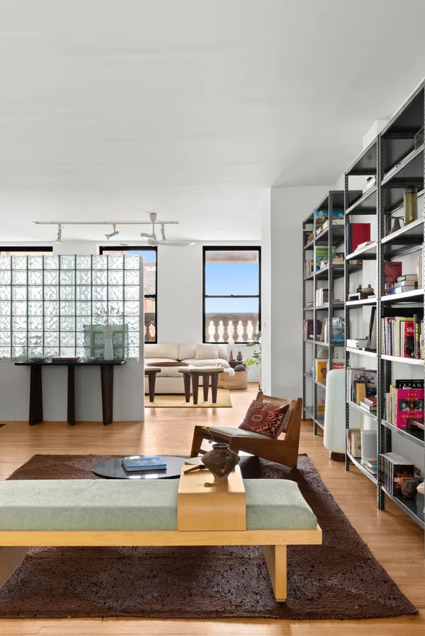 a living room with furniture and a book shelf