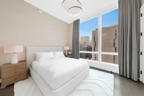 a bedroom with a large bed and a large window