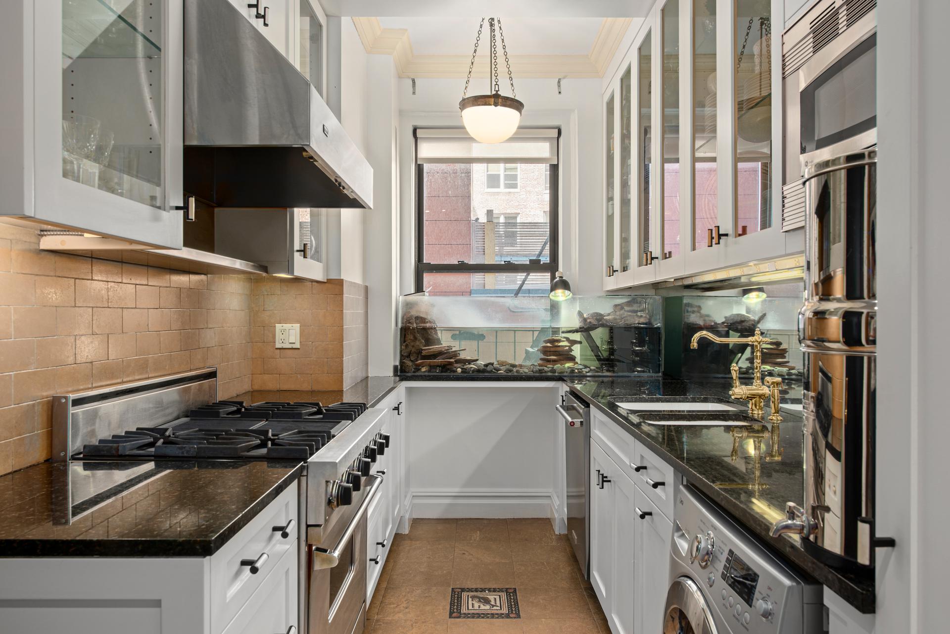 1140 5th Avenue, Unit 8C Manhattan, NY 10128 - Photo 6 of 16 a kitchen with a sink stove top oven and cabinets