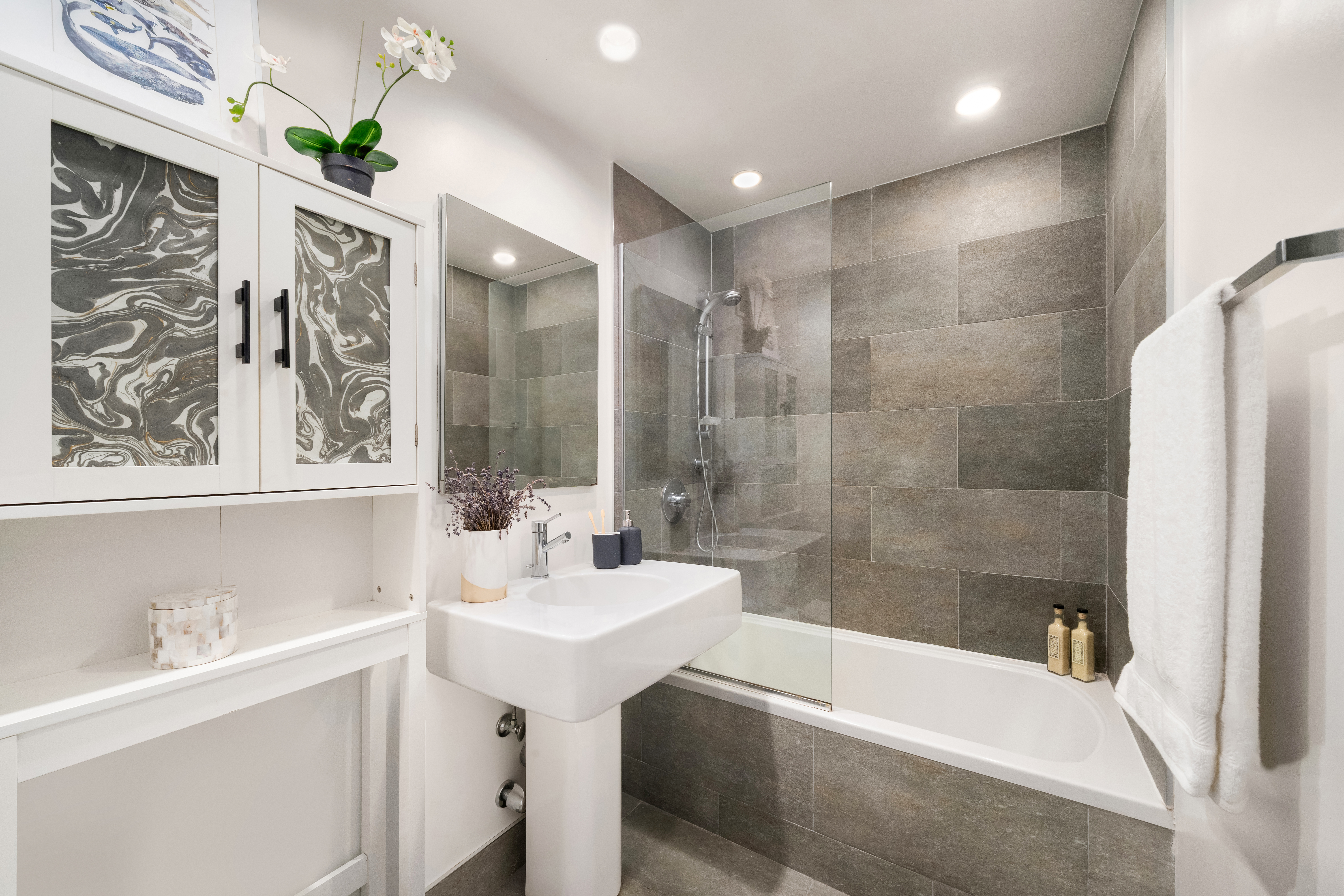 99 Bank Street, Unit 5G Manhattan, NY 10014 - Photo 6 of 9 a bathroom with a sink tub shower and a mirror
