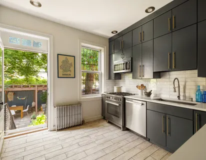 a kitchen with stainless steel appliances granite countertop a stove a sink dishwasher a refrigerator and a microwave oven with wooden floor