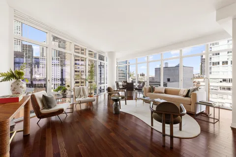 a living room with furniture and floor to ceiling windows