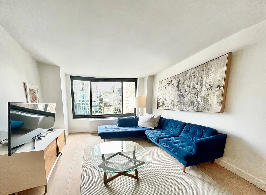 200 Rector Place, Unit 37J Manhattan, NY 10280 - Photo 3 of 12 a living room with furniture and a flat screen tv