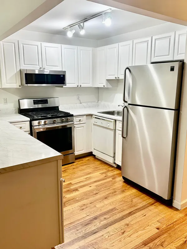 a kitchen with stainless steel appliances granite countertop a refrigerator stove a sink dishwasher and a refrigerator