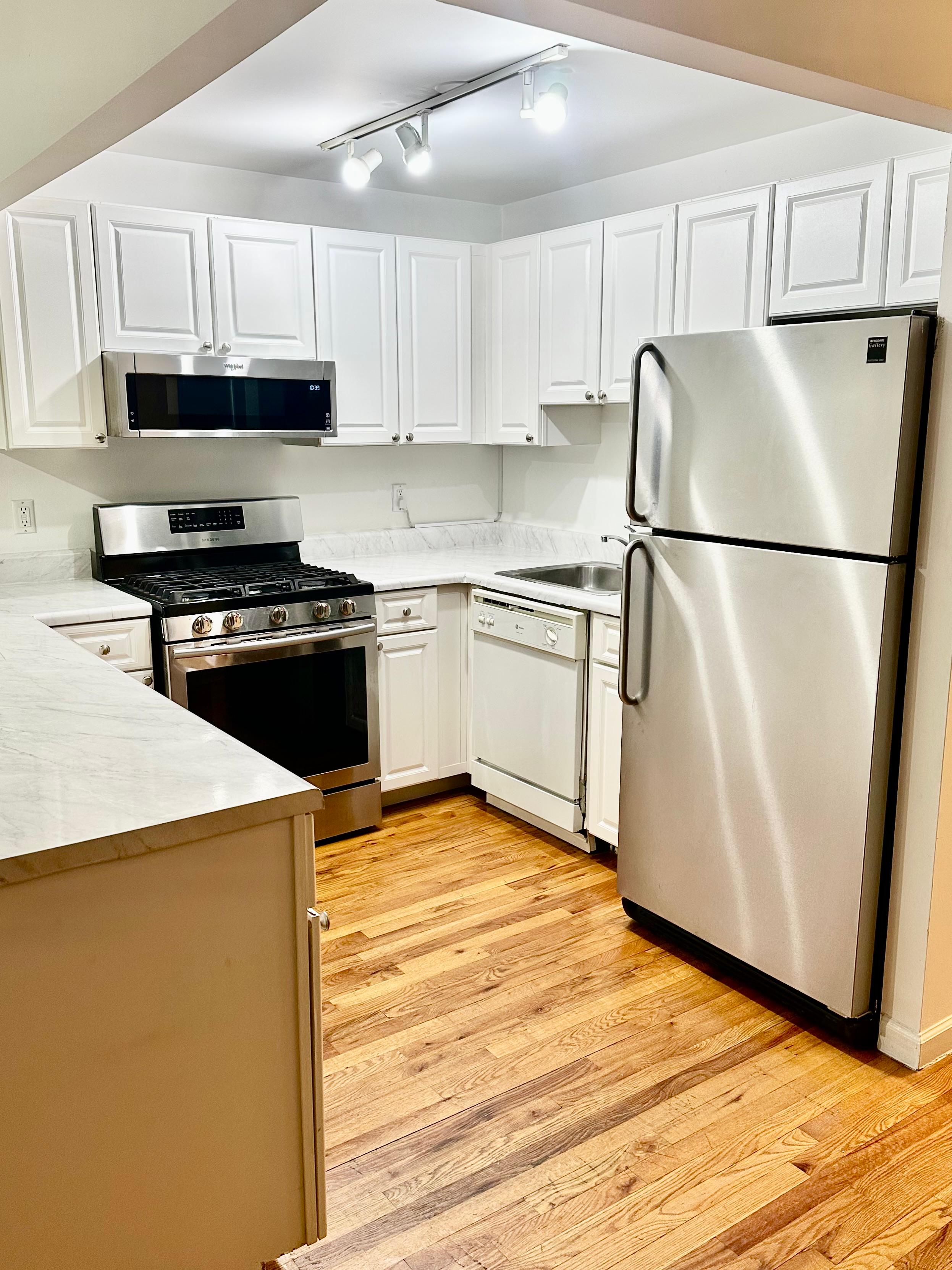 710 St Nicholas Avenue, Unit 1 Manhattan, NY 10032 - Photo 3 of 15 a kitchen with stainless steel appliances granite countertop a refrigerator stove a sink dishwasher and a refrigerator