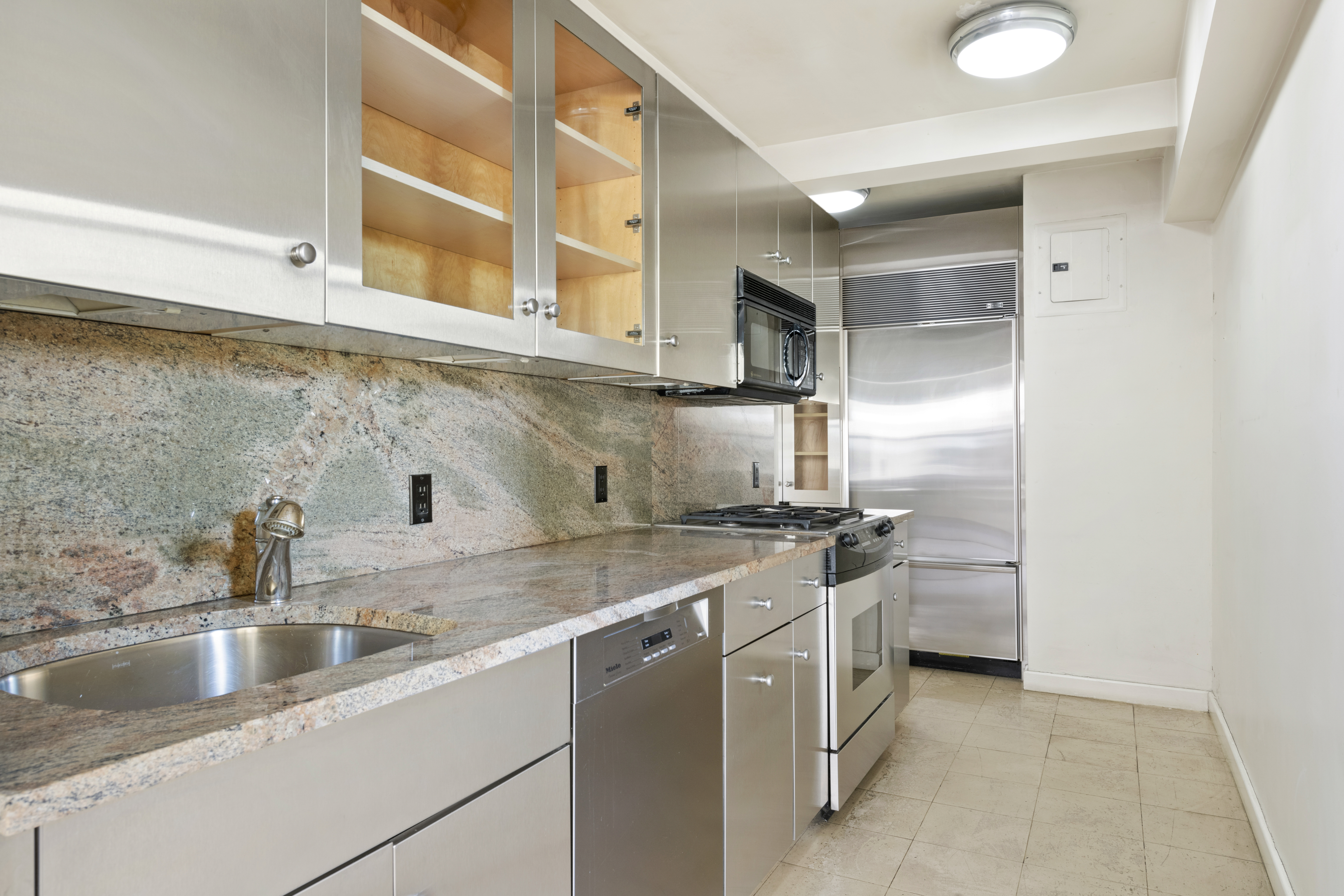 1025 5th Avenue, Unit 7AS Manhattan, NY 10028 - Photo 9 of 16 a kitchen with stainless steel appliances granite countertop a sink and a stove