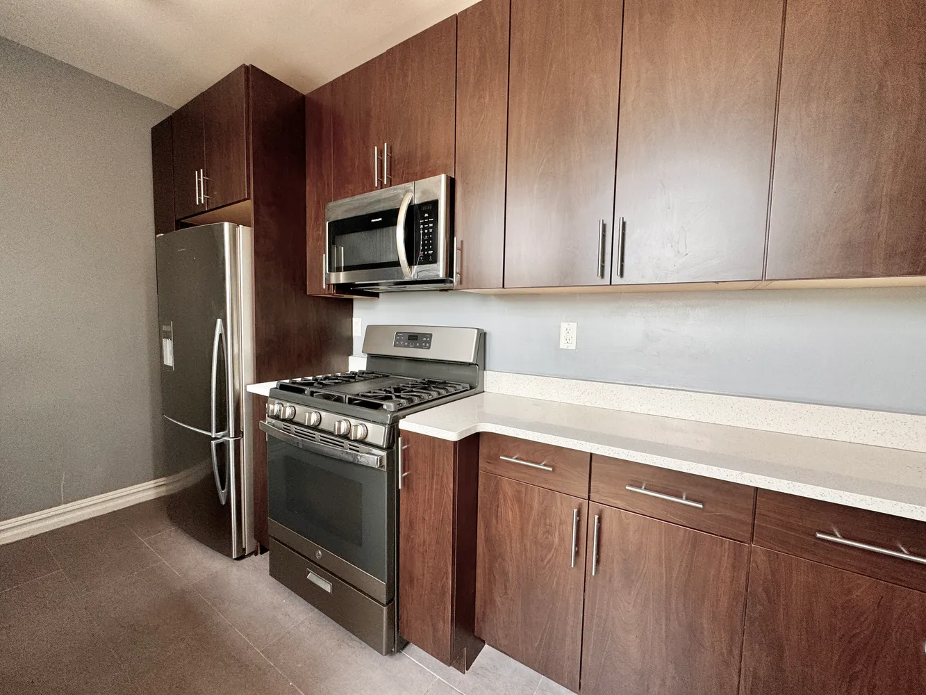 a kitchen with stainless steel appliances granite countertop a stove microwave and refrigerator