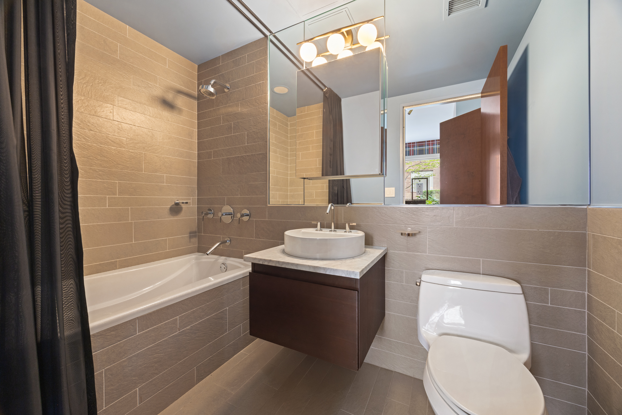 462 West 58th Street, Unit 9B Manhattan, NY 10019 - Photo 13 of 17 a bathroom with a sink a toilet and bathtub