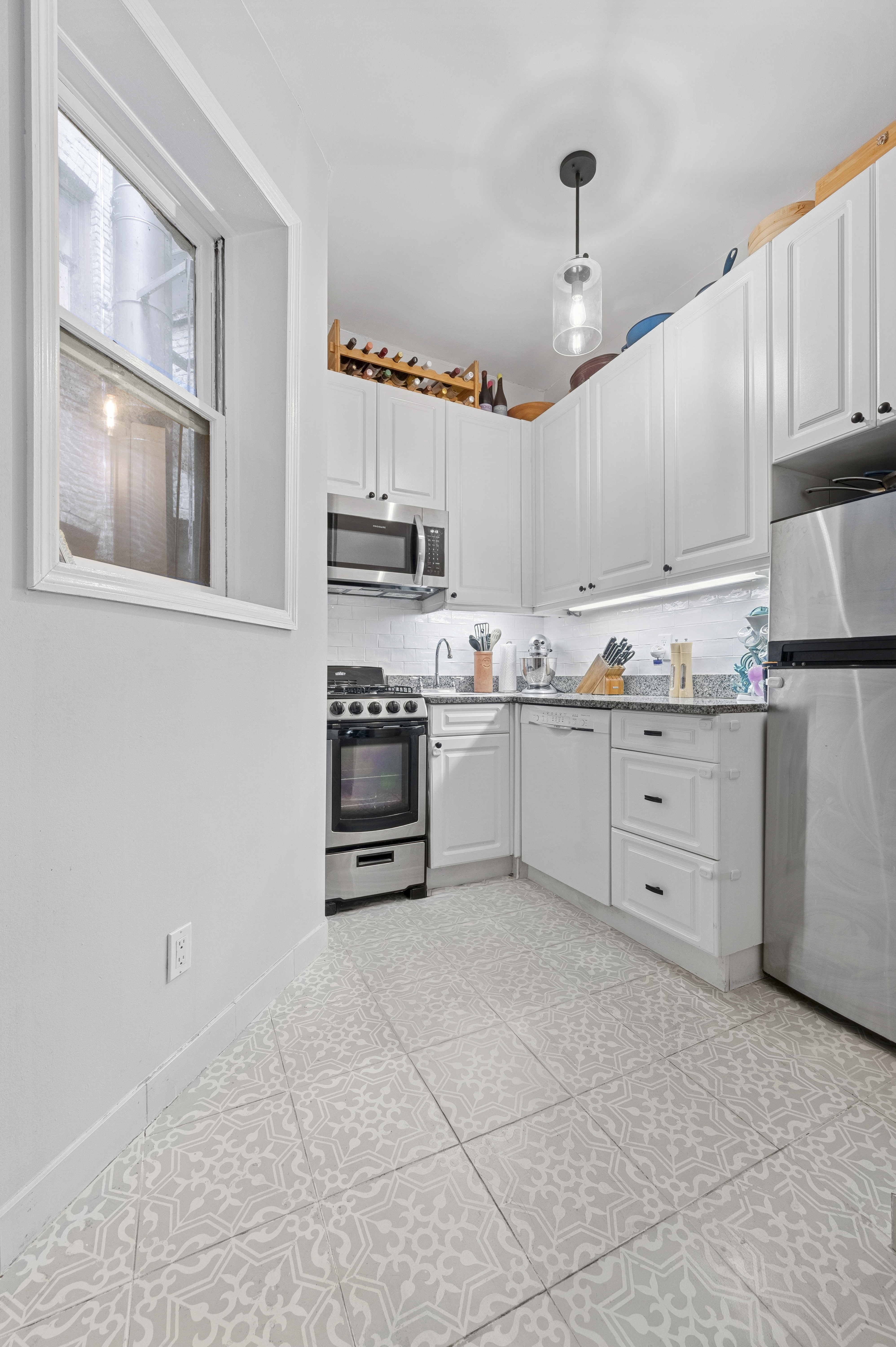 331 East 92nd Street, Unit 4B Manhattan, NY 10128 - Photo 3 of 7 a kitchen with cabinets a window and appliances
