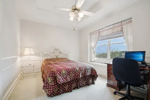 a bedroom with a bed chair and a large window