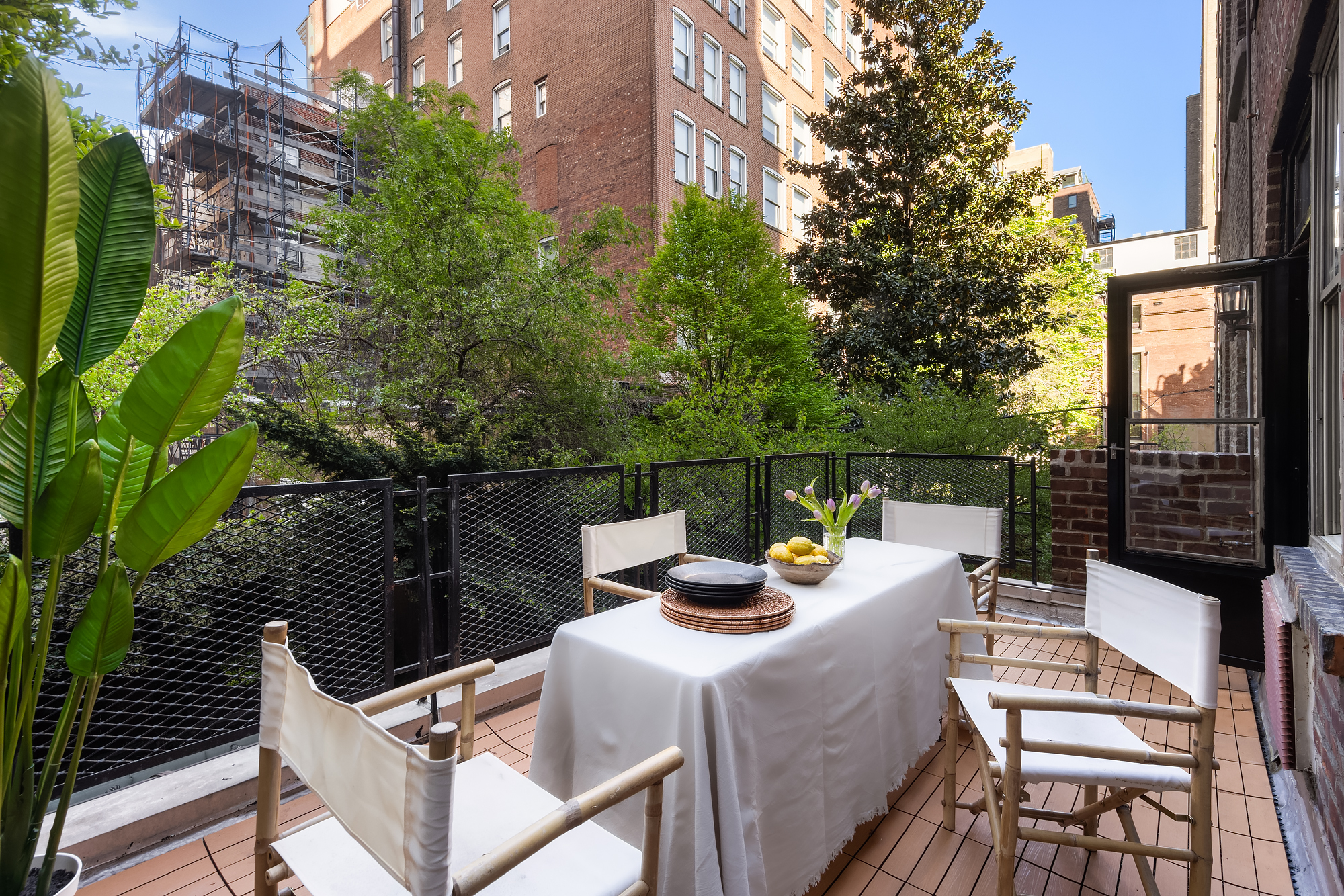 159 West 13th Street Manhattan, NY 10011 - Photo 17 of 36 a view of a roof deck with dining table and chairs with wooden floor and fence