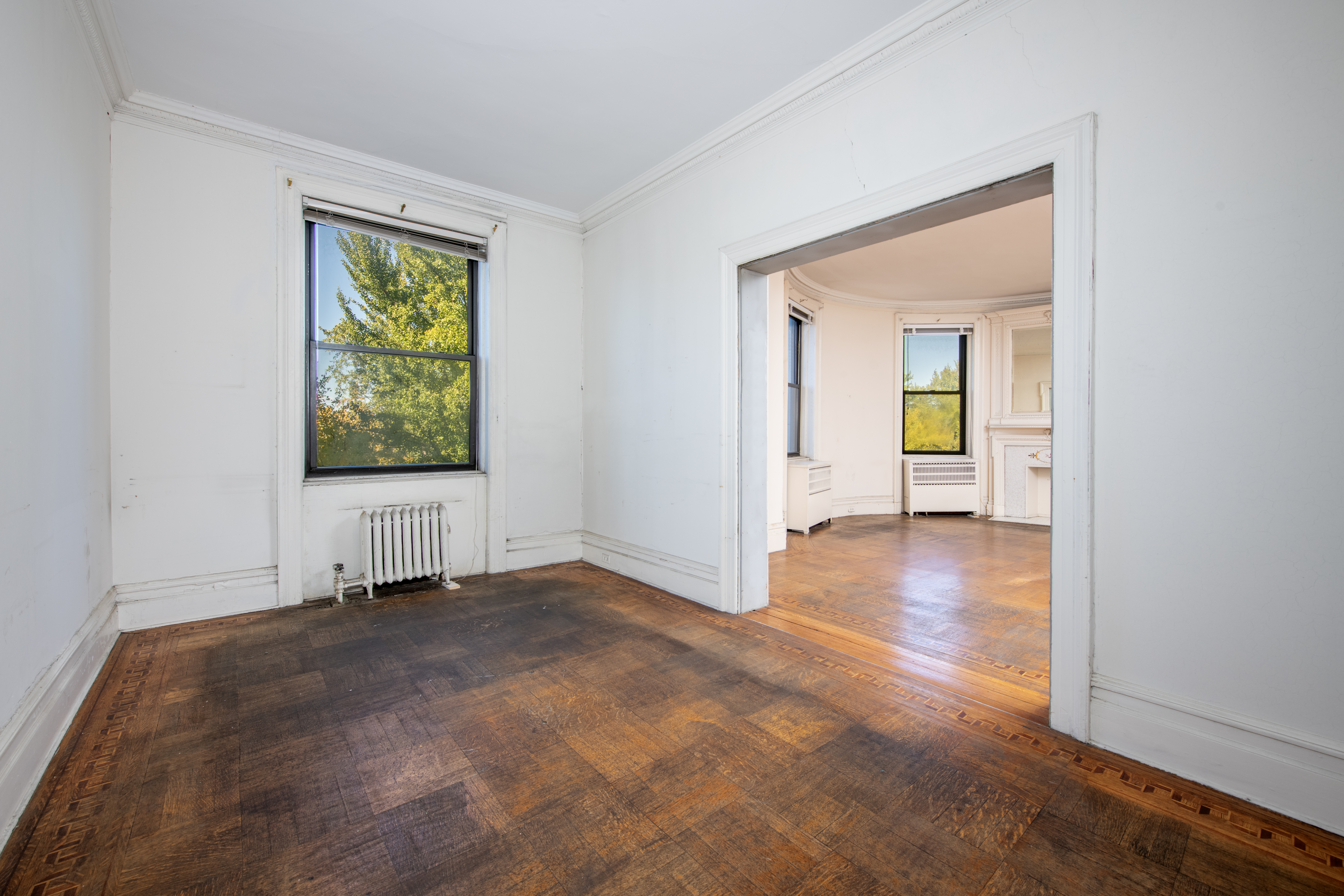 194 Riverside Drive, Unit 5E Manhattan, NY 10025 - Photo 5 of 26 an empty room with window and wooden floor