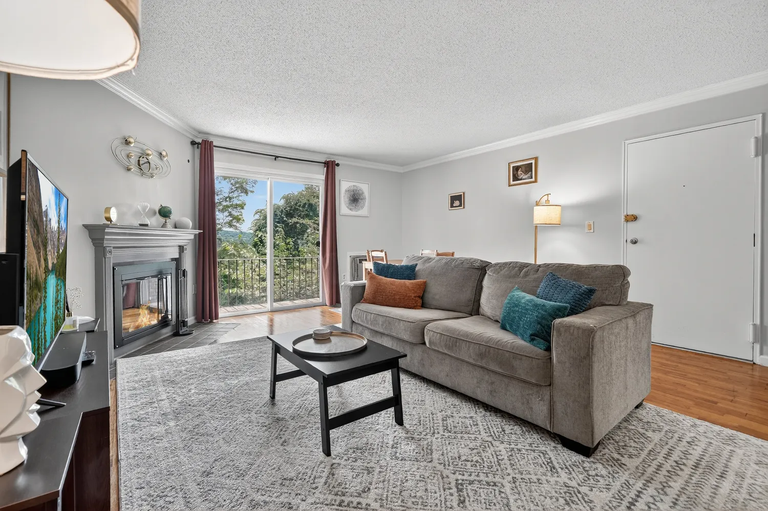 a living room with furniture a flat screen tv and a large window